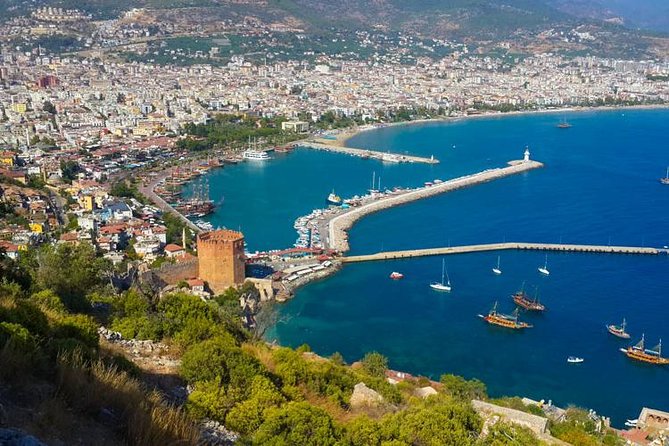 Alanya Catamaran Boat Tour with Sunbathing Swimming & Snorkelling - Seeing the Red Tower, shipyard, and castle from offshore